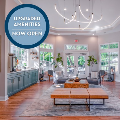 Clubhouse boasting upgraded amenities, enveloped by large windows overlooking a cozy seating area adjacent to a coffee station at Jefferson at the Perimeter in Dunwoody, GA.